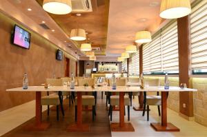 a dining room with tables and chairs and lights at Hotel Porto In in Kotor