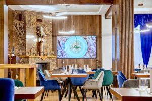 a restaurant with tables and chairs and a fireplace at Kayus in Buşteni