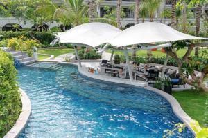 a pool with an umbrella in a resort at Melia Koh Samui in Choeng Mon Beach