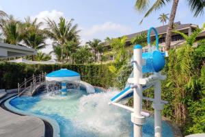 a water slide in a pool at a resort at Melia Koh Samui in Choeng Mon Beach