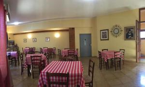 un ristorante con tavoli e sedie rossi e bianchi di Hotel Sant'elene a Dorgali