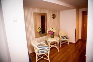 een eetkamer met stoelen en een tafel met bloemen bij Isabel Rooms - Suarez Inclán 38 in Cudillero