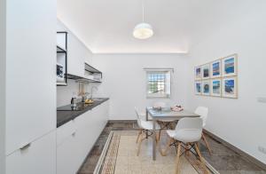 a kitchen with white walls and a table and chairs at Appartamenti Vista Duomo - Ibla - Pomelia in Ragusa +86 photos