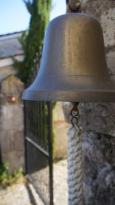 a bell attached to a wall with a chain at Bois de Cadène in Saint-Pierre-de-Buzet