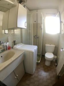 uma casa de banho com um lavatório, um WC e um chuveiro em AS7601 - P2 au coeur du centre ville à 2 pas de la plage em Le Grau-du-Roi