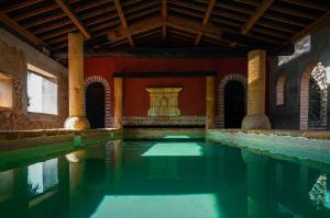 a pool of water in a building with a fountain at Studio et colocation - Gîte Les 7 fontaines in Chevinay