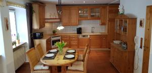 Ferienhaus Dorfschmiede في شْفوناو: مطبخ مع طاولة خشبية مع كراسي واغطية طاولة