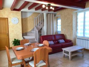 a living room with a table and a red couch at Les gites de la Planchette in Saint-Gervais-les-Trois-Clochers +34 photos