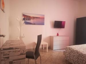 a bedroom with a bed and a desk and a tv at B&B Metro Salerno in Salerno