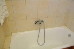 a bath tub with a shower head in a bathroom at The Piano apartment in Perdika