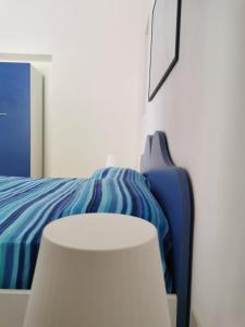 una camera con un letto blu e una sedia bianca di ANFORA Blu a Canneto
