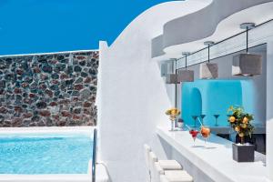 a villa with a swimming pool and white walls at Canaves Oia Boutique Hotel in Oia