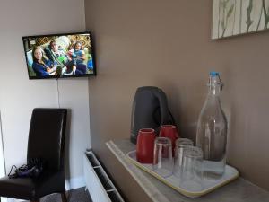 a table with a bottle and cups and a television at O'Donnell's Of Donegal in Donegal