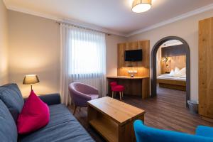 a living room with a couch and a bedroom at Hotel & Gasthof Richard Held in Regensburg
