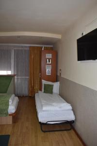 a room with two beds and a flat screen tv at Hotel Zimbru in Cluj-Napoca