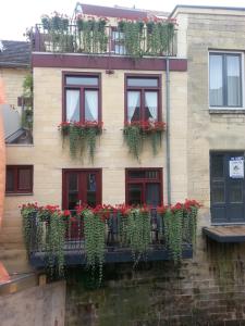 een gebouw met rode bloemen en planten erop bij Gastsuite in Valkenburg aan de Geul in Valkenburg