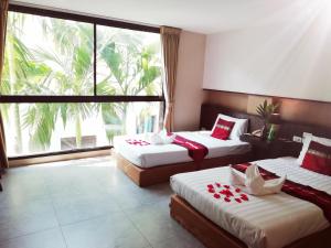 a hotel room with two beds and a large window at Mandala House, Chiang Mai in Chiang Mai +67 photos