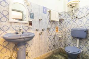 een badkamer met een wastafel, een toilet en een spiegel bij Zostel Gangtok in Gangtok