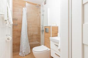 La salle de bains blanche est pourvue d'une douche et de toilettes. dans l'établissement Apartment Nevada Gdańsk Przymorze by Renters, à Gdańsk