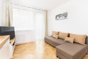 sala de estar con sofá y TV en Apartment Nevada Gdańsk Przymorze by Renters en Gdansk