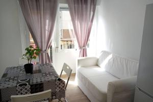 a living room with a white couch and a table at Apartamentos en Alameda junto al Corte Inglés in Cartagena
