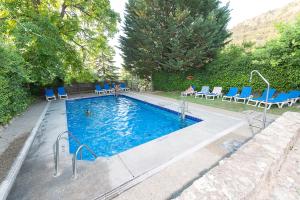 - une piscine avec des chaises bleues dans l'établissement Villa Turística de Cazorla, à Cazorla