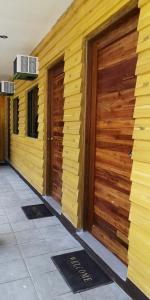 two wooden doors on the side of a building at Rain Haven Lodging House in Coron