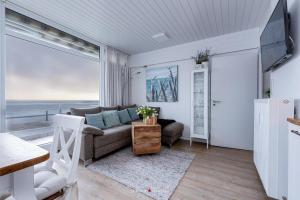 a living room with a couch and a view of the ocean at Bellevue B21 in Großenbrode
