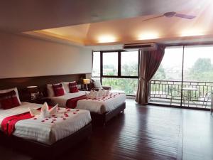 a hotel room with two beds and a balcony at Mandala House, Chiang Mai in Chiang Mai