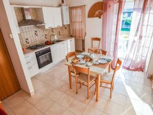 een keuken met een houten tafel en stoelen en een keuken met een fornuis bij Apartment Green Marine- Palme- Ismare-7 by Interhome in Silvi Marina
