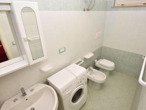 a bathroom with a sink and a washing machine in it at Studio Green Marine- Palme- Ismare-11 by Interhome in Silvi Marina