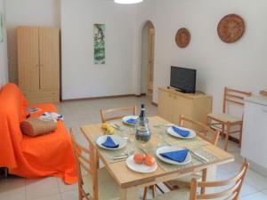 una sala da pranzo con tavolo, sedie e TV di Apartment Green Marine- Palme- Ismare-1 by Interhome a Silvi Marina