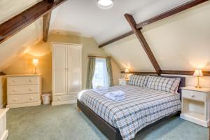 1 dormitorio con 1 cama y 2 mesitas de noche en La Bellieuse Cottages en St Martin Guernsey