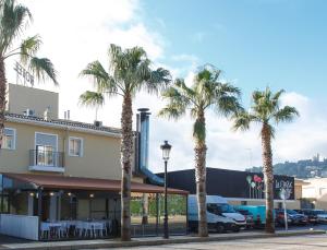 a group of palm trees in front of a building at La Orza de Angel in Chiva