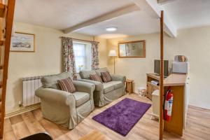 a living room with a couch and a tv at La Bellieuse Cottages in St Martin Guernsey