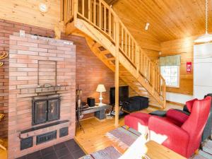 a living room with a red couch and a fireplace at Holiday Home Käränkämökki by Interhome in Kolinkylä +13 photos