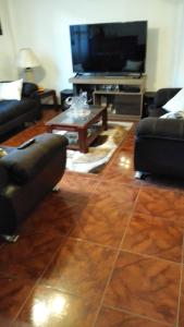 Sala de estar con 2 sofás y TV en Apart & Hostal ManuAlé, en Tacna