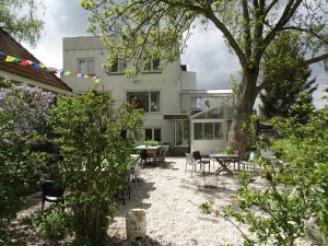 a house with chairs and tables in a yard at Boutiquehotel B&B the SJinn in Schin op Geul