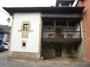 a white building with a balcony and tables on it at El Nozalon Picos de Europa in Poo de Cabrales