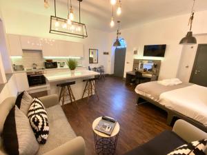 a living room with a bed and a kitchen at Studio at The Coach House Apartments in Leeds