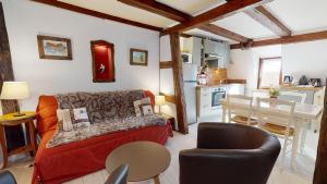 a living room with a red couch and a kitchen at Le Clos bartholdi in Colmar