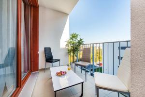 balcón con mesa blanca y sillas en REZIDENCE ŠVEHLOVA, en Praga