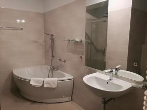 een badkamer met een bad en een wastafel bij Yuca in Łódź