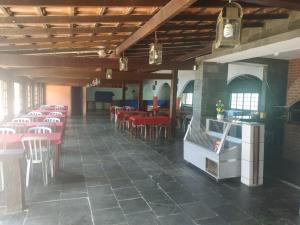 a dining room with red tables and chairs at Pousada Lagoa de Araruama in Araruama