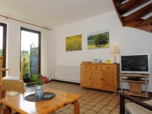 ein Wohnzimmer mit einem TV und einem Tisch in der Unterkunft La Casa Ferienwohnung Möwe in Steinberg