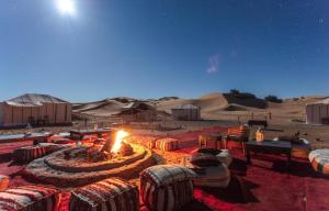 a fire pit in the middle of the desert at Erg Chebbi Luxury Desert Camp in Merzouga