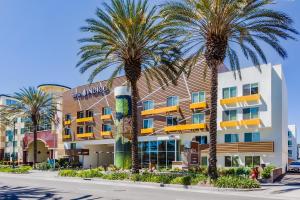 a hotel with palm trees in front of it at Hotel Indigo Anaheim, an IHG Hotel in Anaheim