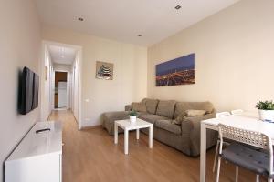 ein Wohnzimmer mit einem Sofa und einem Tisch in der Unterkunft MUNNE - Spacious apartments FC Barcelona in Barcelona