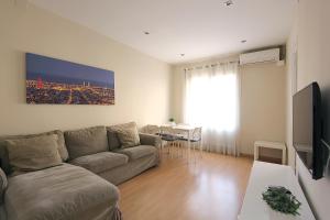 a living room with a couch and a table at MUNNE - Spacious apartments FC Barcelona in Barcelona