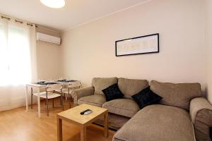 a living room with a couch and a table at MUNNE - Spacious apartments FC Barcelona in Barcelona